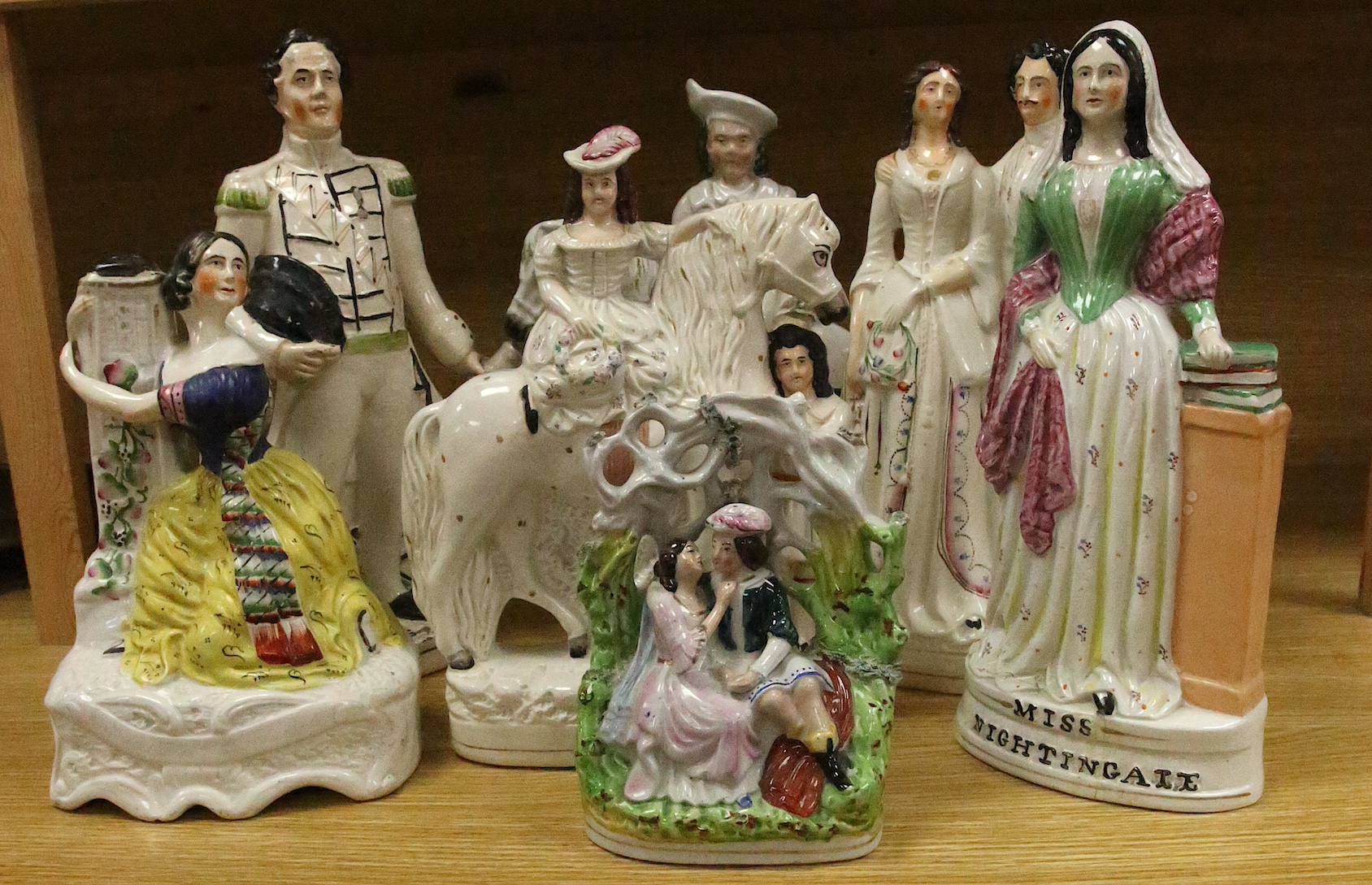 Staffordshire pottery: a bocage group, 25.5cm, 'Huntsman' 40.5cm, figure with child groom 40.5cm, figure of girl beside a column 30cm, George and Eliza Harris, 36cm, 'Dundas' beside a cannon, 40.5cm, gentleman and lady h